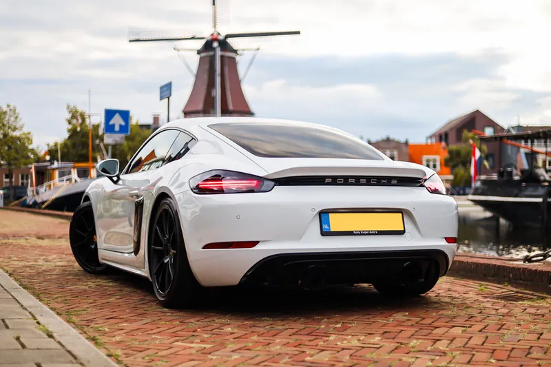Achterzijde van de Porsche 718 Cayman met molen en gracht