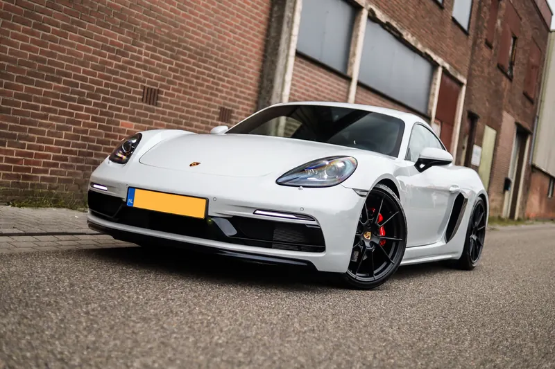 Porsche 718 Cayman tegen een bakstenen gevel
