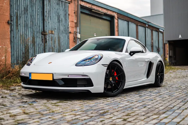 Porsche 718 Cayman voor een industriële bakstenen gevel