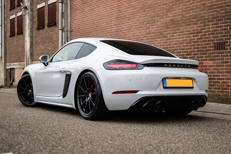 Porsche 718 Cayman op kinderkopjes bij oude bedrijfspanden