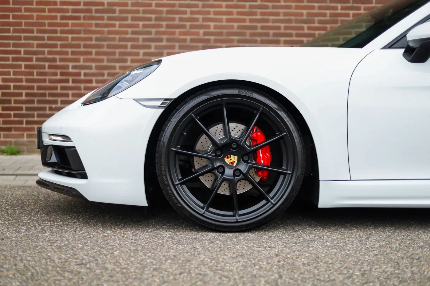 Porsche 718 Cayman schuin van achteren gezien op straat